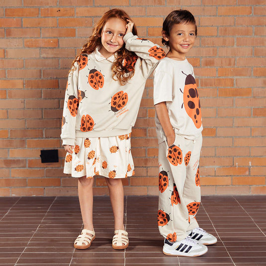Pantalón infantil beige con mariquitas Ladybug, tipo sudadera infantil para niños y niñas, con cintura elástica y ajustable con cordón y bolsillos laterales, estampado completo de mariquitas - LOBSTER mini