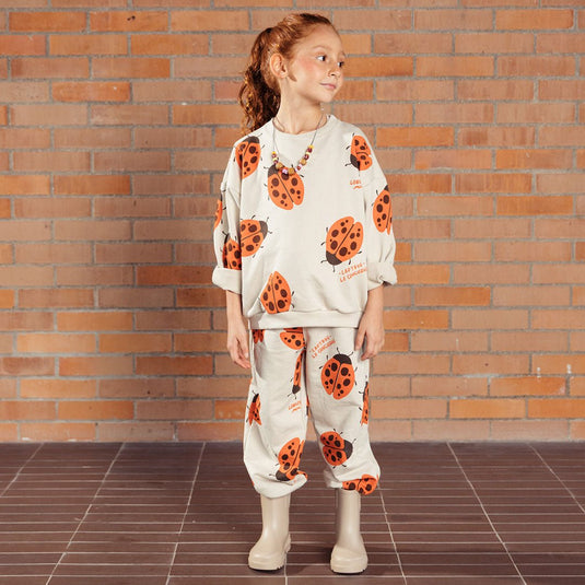 Pantalón infantil beige con mariquitas Ladybug, tipo sudadera infantil para niños y niñas, con cintura elástica y ajustable con cordón y bolsillos laterales, estampado completo de mariquitas - LOBSTER mini
