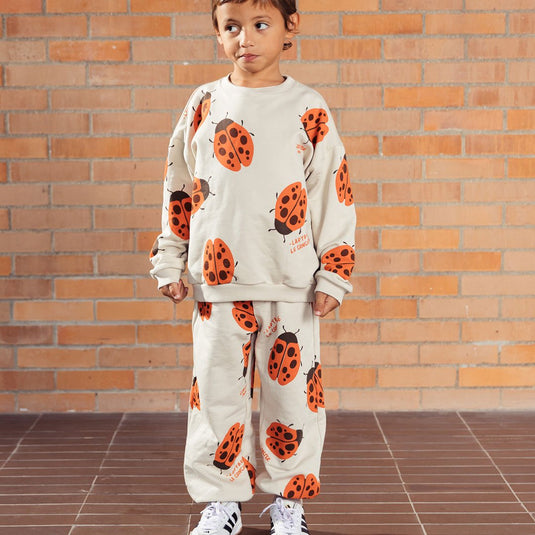 Pantalón infantil beige con mariquitas Ladybug, tipo sudadera infantil para niños y niñas, con cintura elástica y ajustable con cordón y bolsillos laterales, estampado completo de mariquitas - LOBSTER mini