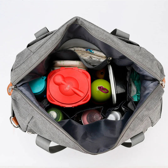 Bolso pañalera con diseño frontal tejido y monedero