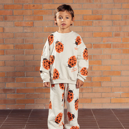 Buzo infantil beige con mariquita Ladybug, estampado total de mariquitas naranjas y la frase “The ladybug concierge”, prenda Unisex y versátil, tela suave y abrigadora para días frescos - LOBSTER mini
