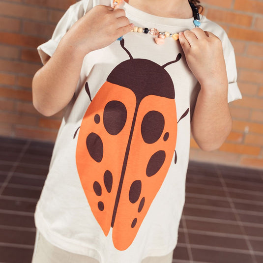 Camiseta infantil Concierge estampado mariquita naranja, hecha con material de alta calidad que brinda suavidad extrema, frescura y resistencia, ideal para acompañar a los más pequeños en todas sus aventuras - LOBSTER mini - Cocco Semana 2026