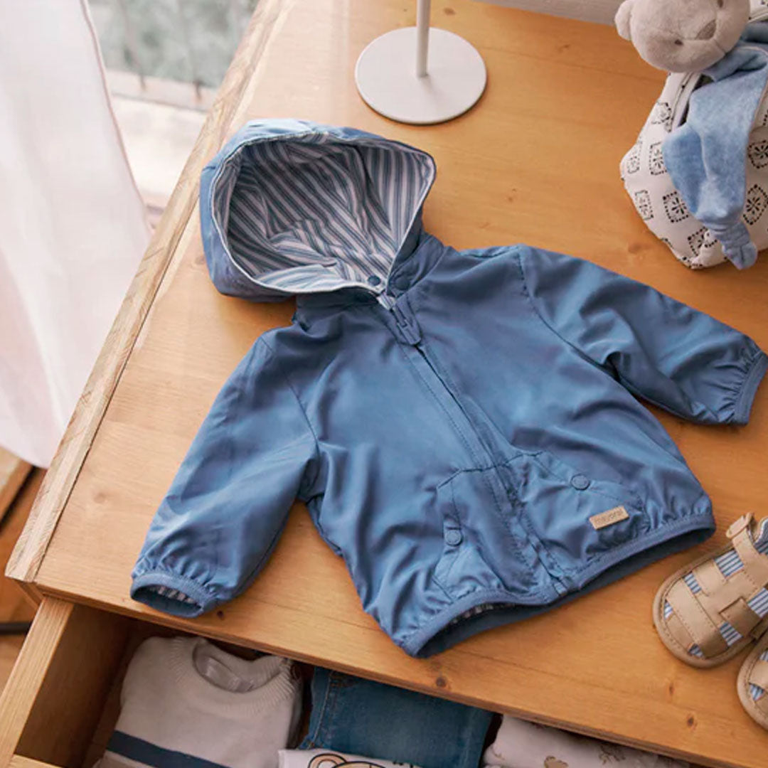 Chaqueta cortavientos azul con diseño reversible, cuenta con capucha removible con botones, diseño doble faz ideal para combinar - Mayoral