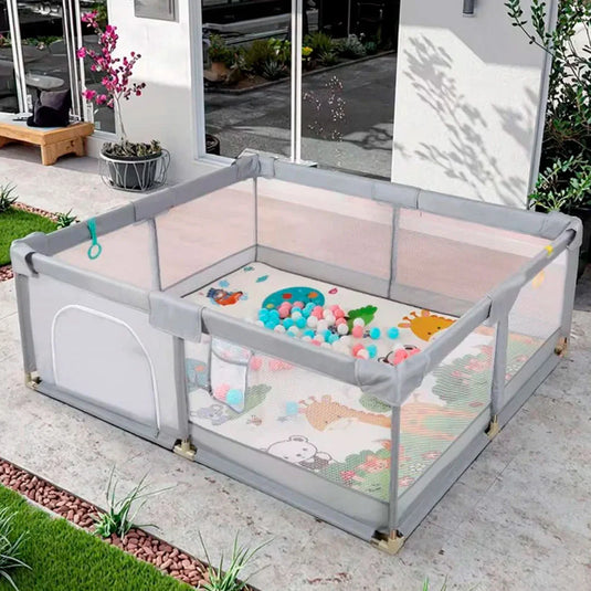 Corral de juego color gris con tapete didáctico de dobleces, hecho en material resistente, con laterales en malla, puerta con cierre para facilitar el ingreso, incluye pelotitas y dos agarraderas