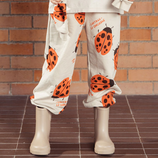 Pantalón infantil beige con mariquitas Ladybug, tipo sudadera infantil para niños y niñas, con cintura elástica y ajustable con cordón y bolsillos laterales, estampado completo de mariquitas - LOBSTER mini