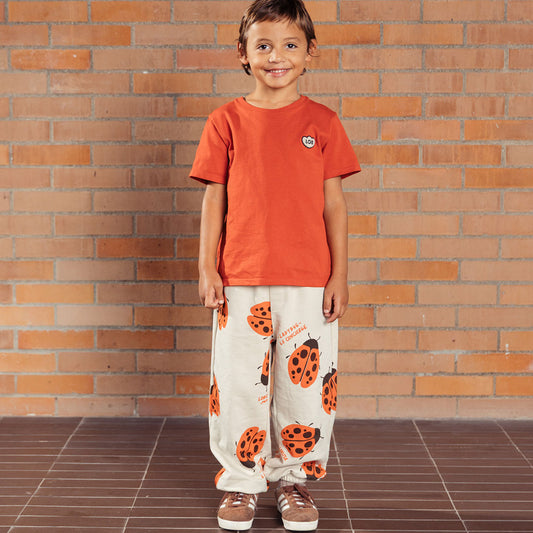 Pantalón infantil beige con mariquitas Ladybug, tipo sudadera infantil para niños y niñas, con cintura elástica y ajustable con cordón y bolsillos laterales, estampado completo de mariquitas - LOBSTER mini